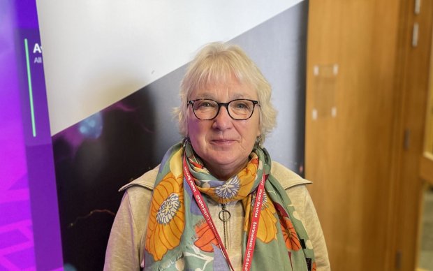 A head shot of Mary wearing glasses and a colourful scarf.