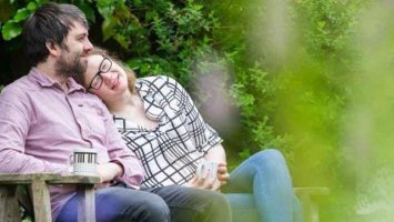 Photo: Young couple sat on bench in garden
