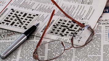 Newspaper crossword & glasses