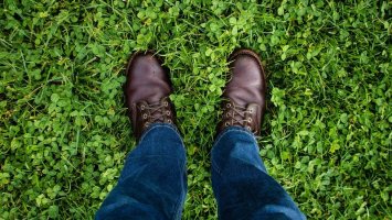 Close up of feet in brown shoes on grass