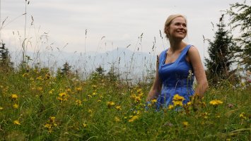 Eleni in a meadow wearing a blue dress