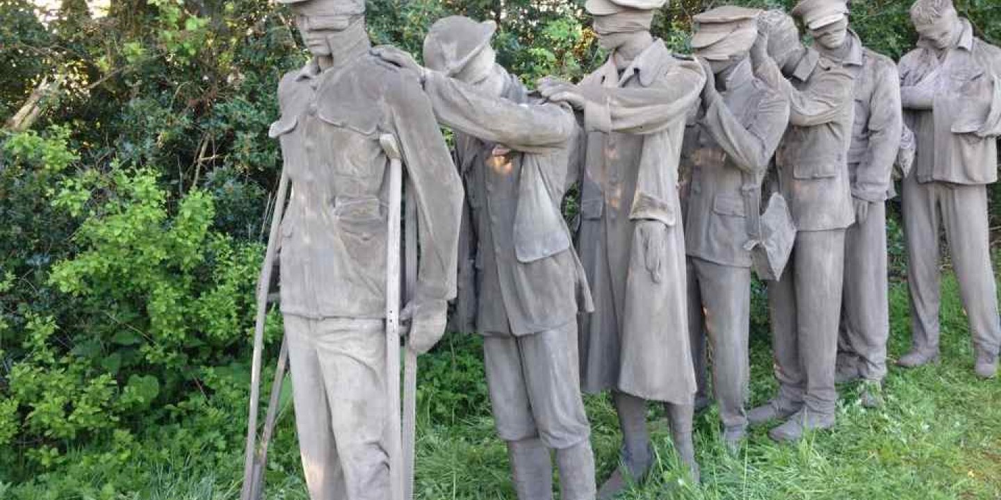 Sculpture of WW1 soldiers in concrete outside on grass
