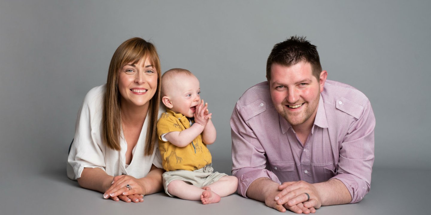 Professional studio image of Nicola, baby and husband