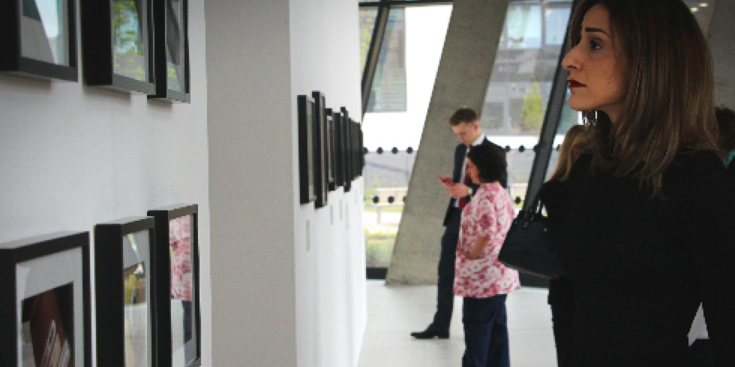 A woman looking at pictures at an exhibiton