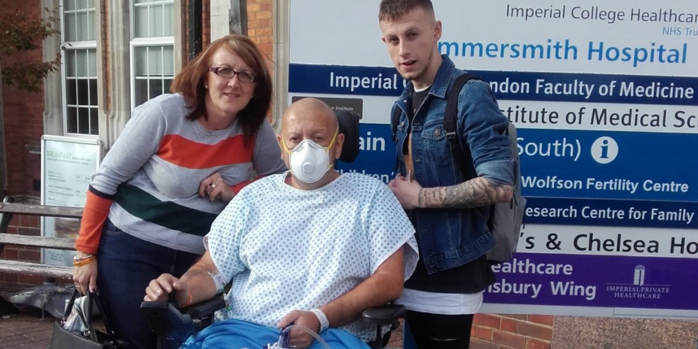 Roy Porter outside hospital wearing mask, with his wife and son