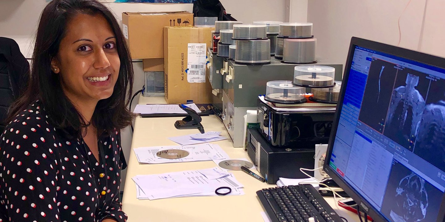 Anisha sits at her computer at work