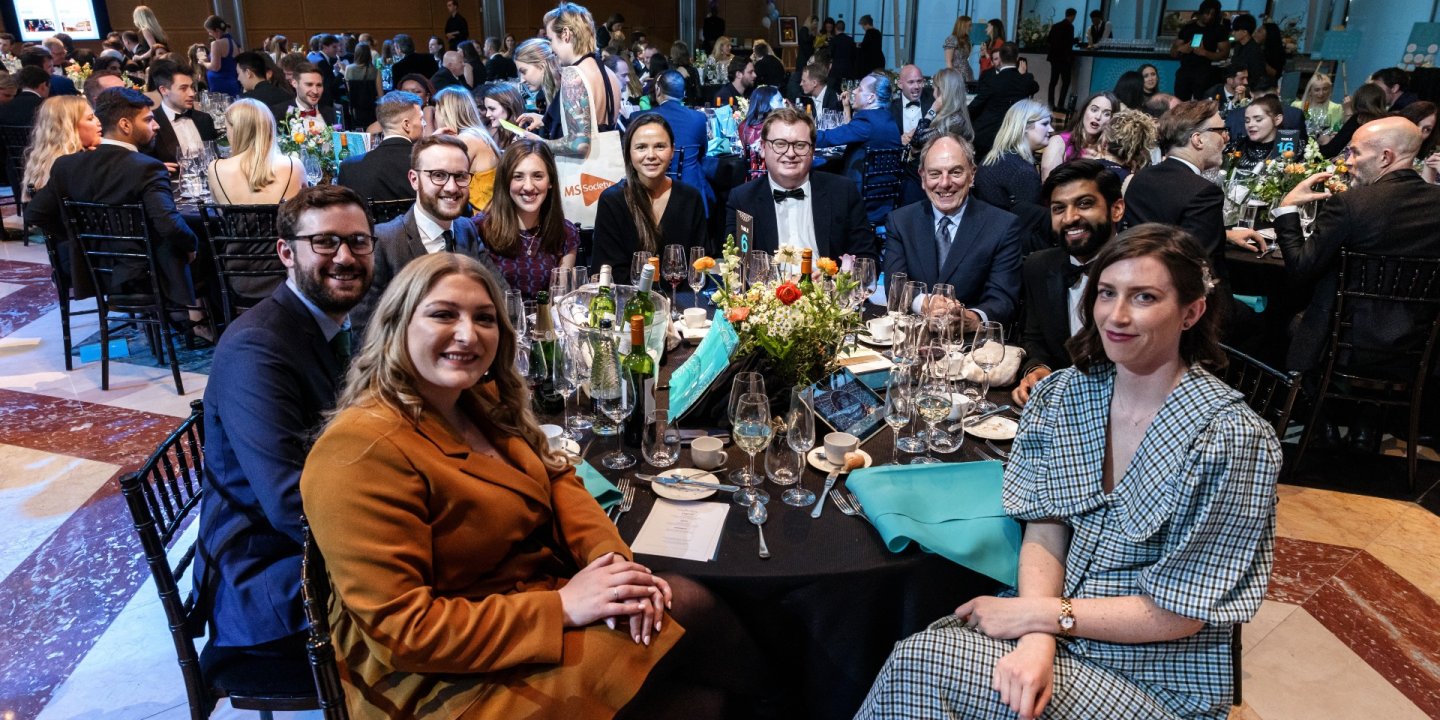 A table of guests smiles at the camera at SMS Battles. Photo copyright Brendan Foster 