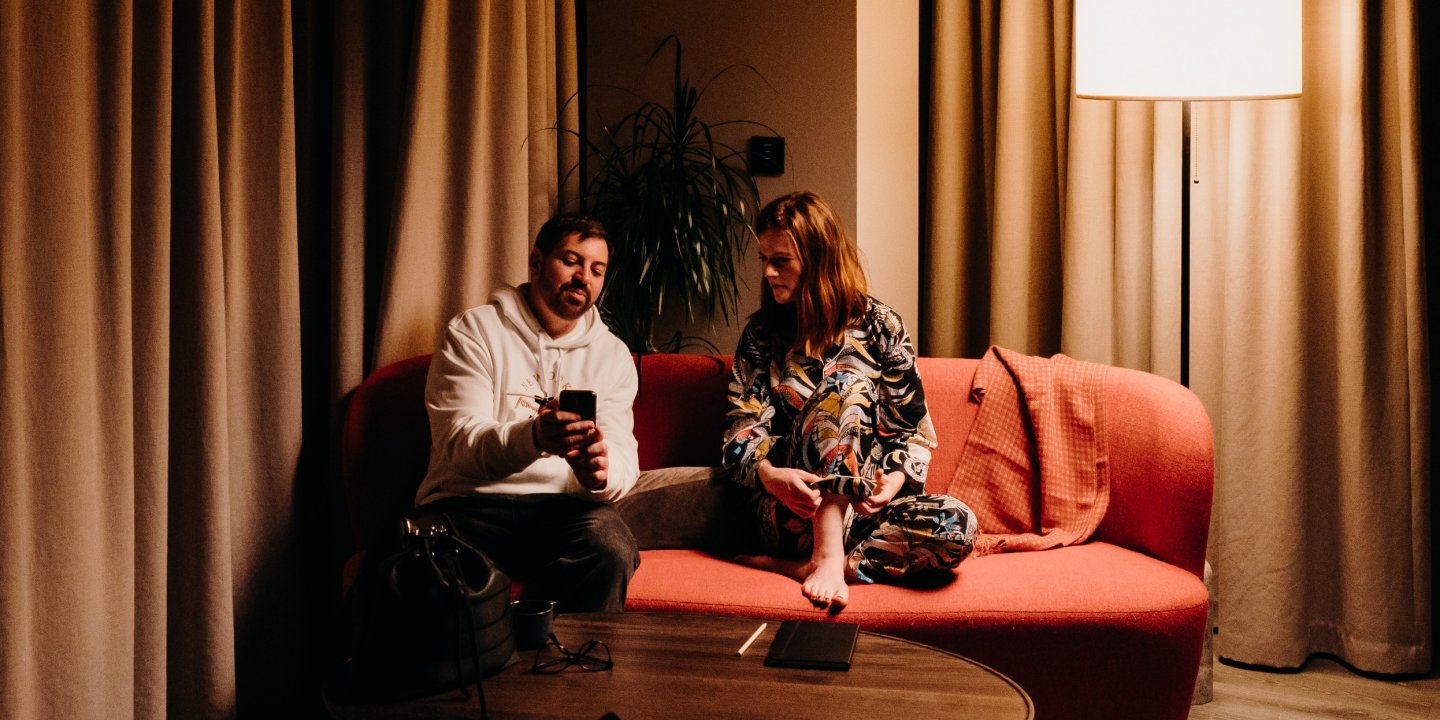 Rose and Fabio sitting on a sofa, talking. Photo by Ralu Chase.