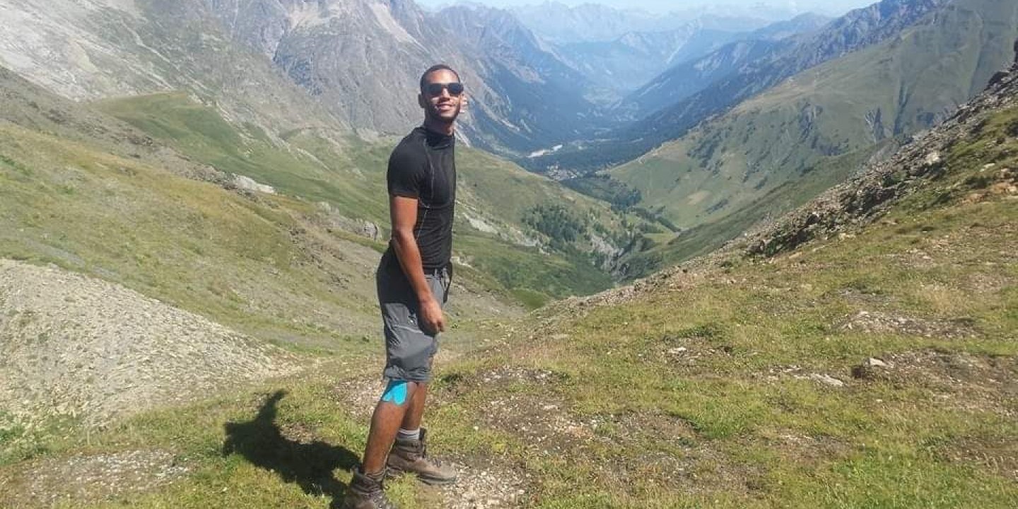 Stefan Taylor standing in the hills in the sun, wearing sunglasses