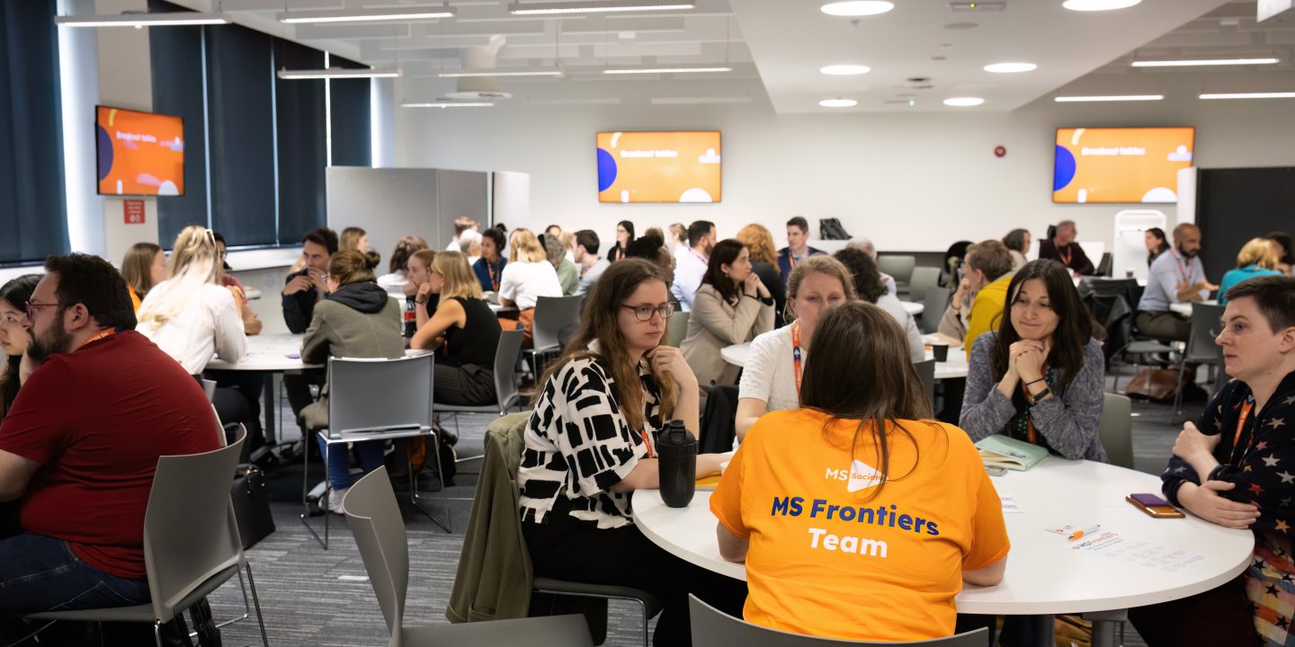 Groups of people sat around tables at a conference