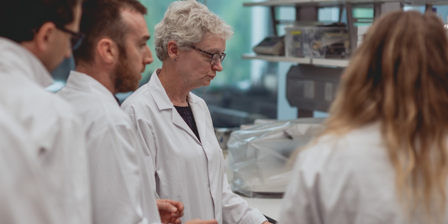 Researchers in white coats in a lab