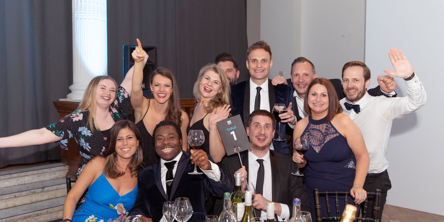 A group of happy people around a table with wine and glasses