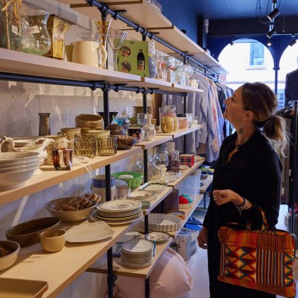 A shopper looks at shelves of bric-a-brac