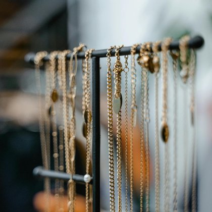Gold necklaces, pendants and chains hung on a display stand