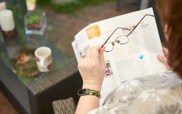 Photo: A woman reading MS matters in the garden