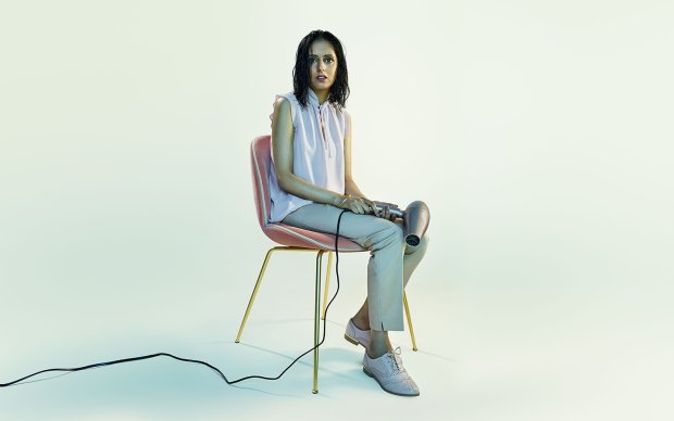 Donna sitting on a chair holding a hairdryer in her lap