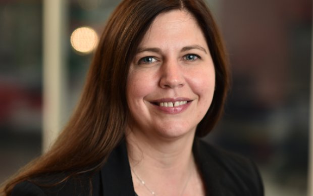 Head and shoulders portrait of Dr Sarah Rawlings facing the camera smiling