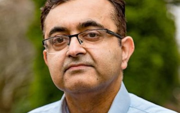 Dr Waqar Rashid, a head shot of a man in blue shirt and glasses with dark brown hair