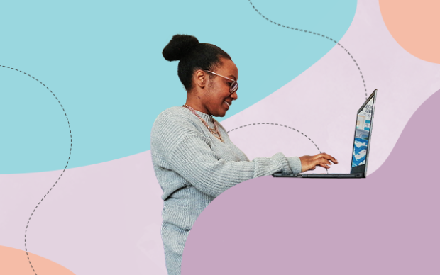 Black woman stands in profile typing into a laptop
