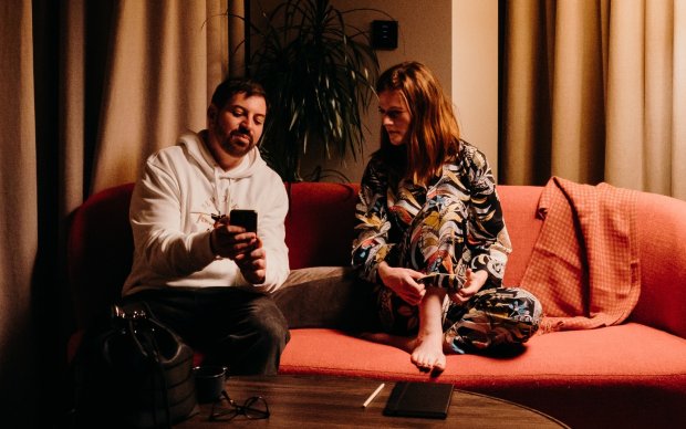 Rose and Fabio sitting on a sofa, talking. Photo by Ralu Chase.