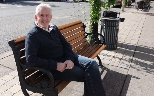 Man sitting on a bench smiling at the camera