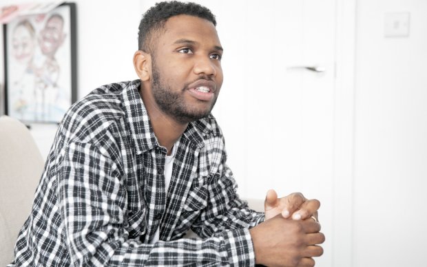  A man sitting on the sofa with his hands clasped