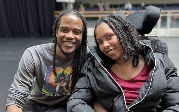 Ekow and Carly smile at the camera.