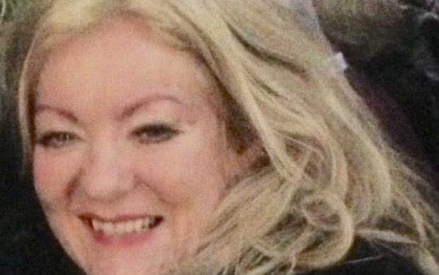 Sheena has long blonde hair and wears a dark coat