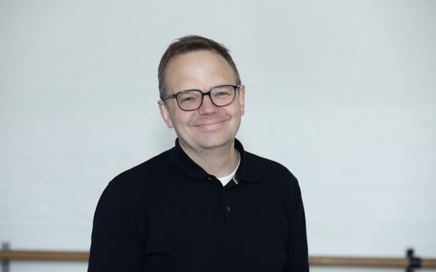 Picture of a man smiling against a white background