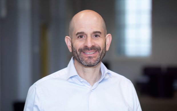 Headshot of David Silver, who wears a white shirt