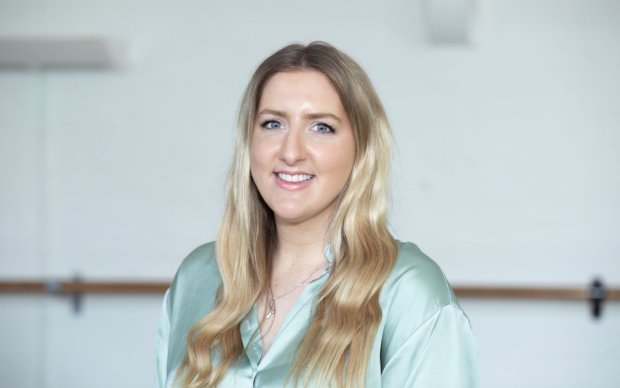 Headshot of Emily, who has long blonde hair, against a white background