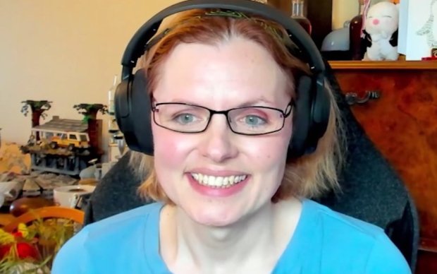 Dr Cora Sergeant wearing headphones and smiling, in front of a microphone