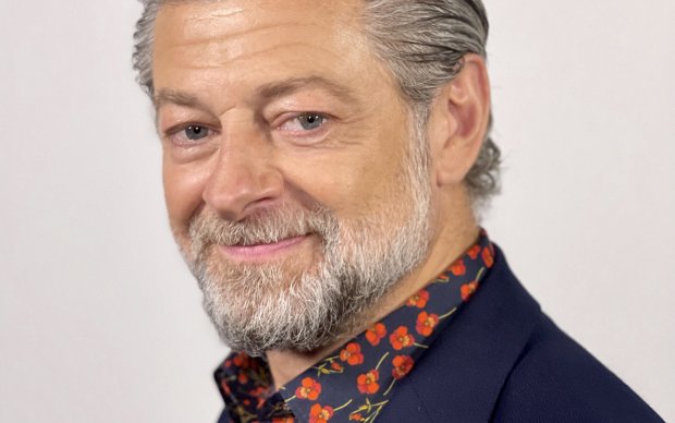 A profile picture of a man smiling at the camera