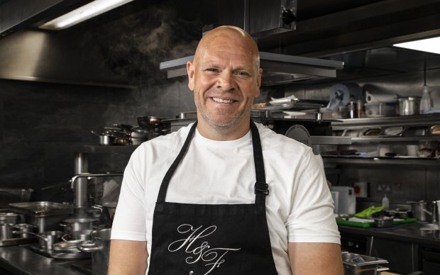 A chef in an apron smiling at the camera