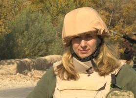 Photo of BBC journalist Caroline Wyatt reporting in flak jacket and helmet