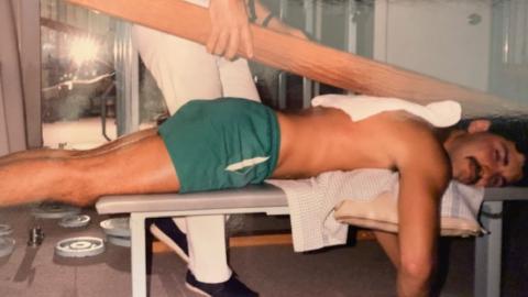 Martin being treated with a large wooden beam