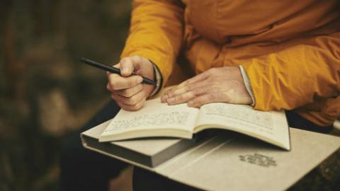 pen in hand and open notebook