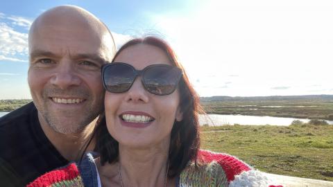 A woman and man taking a selfie on a sunny day in a wetland