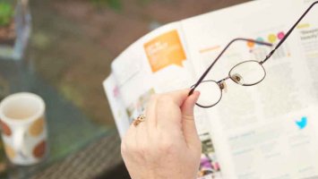 lady with ms putting on her glasses to help with eye pain and vision problems
