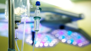 Photo shows infusion bag and injector suspended from metal pole.