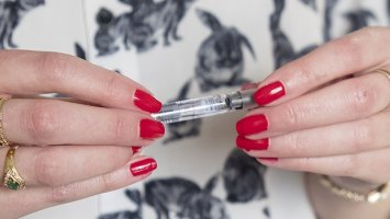 Photo: Kirsty's hands with red nails holding her MS treatment