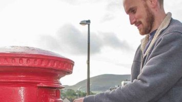 Man drop letter Into postbox