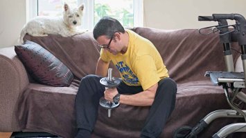 Man with ms exercising at home with dumbells