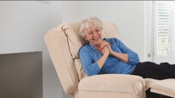 A woman reclines in a Theraposture chair