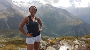 Sadie Williams standing in the Swiss Alps in white shorts and a black vest