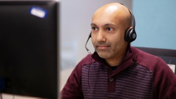 A member of our MS Helpline staff takes a call wearing a headset