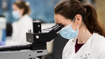 Researcher looking through microscope