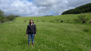 The photo shows Rachel in a field, smiling at the camera.