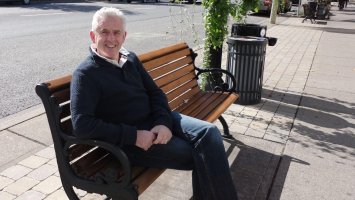 Man sitting on a bench smiling at the camera