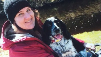 Amy sits with her dog on her lap.